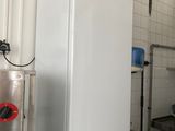 un réfrigérateur blanc au milieu d'une cuisine remplie d'appareils électroménagers