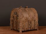 a wooden box with carvings on it on a table