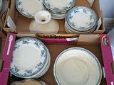 plusieurs assiettes et bols dans une boîte posée sur le sol