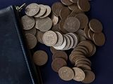 a black wallet and some coins on a table