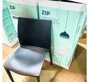 une chaise noire posée devant une pile de cartons