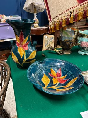 une table verte sur laquelle se trouvent un bol et un vase