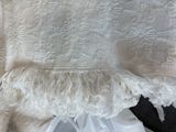 a close up of a white blanket with a white ruffle on it