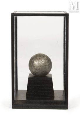 a silver ball in a glass case on a wooden stand