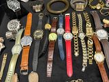 many different types of watches and bracelets laid out on a table