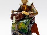 une photo d'une figurine représentant une femme assise sur un banc