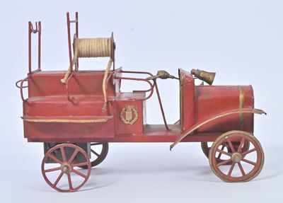 a red toy fire truck with a hose attached to the back of it