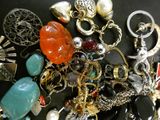 a pile of assorted jewelry on a black surface