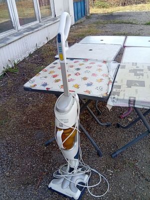 a vacuum that is sitting on the ground near a table