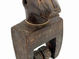 wooden sculpture of a monkey sitting on a wooden block with a chain around its neck