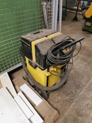 une machine posée par terre à côté d'un tas de bois