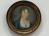 painting of a woman in a blue dress in a gold frame on a white wall