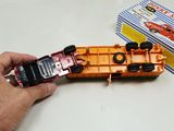 a person holding a cell phone next to a toy boat