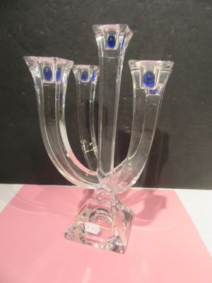 three glass candlesticks with blue eyes on them on a table