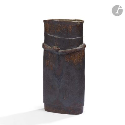 a brown vase that is sitting on a white surface