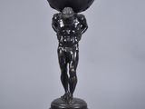 statue of a man holding a clock on his head