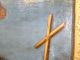 une peinture représentant une croix sur un mur, avec le ciel en arrière-plan