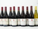 six bouteilles de vin sont alignées sur une surface blanche