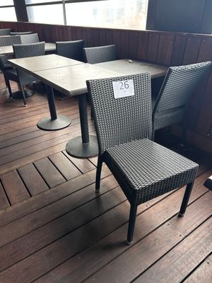 des tables et des chaises posées sur une terrasse en bois, sur lesquelles est posée une plaque d'immatriculation
