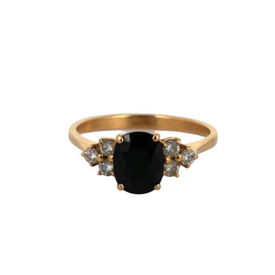 a close up of a gold ring with a black stone