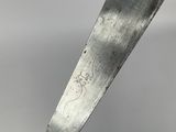 a large knife that is on top of a piece of wood