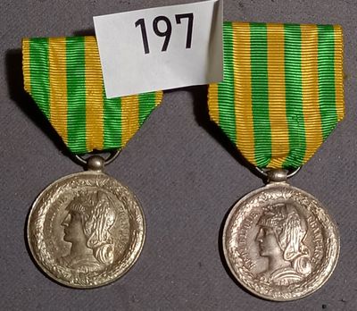 two medals with a ribbon on a table with a name tag on it