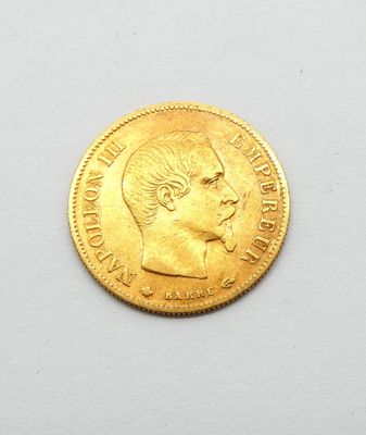 gros plan d'une pièce d'or sur une surface blanche