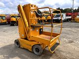 a close up of a yellow scissor parked in a parking lot