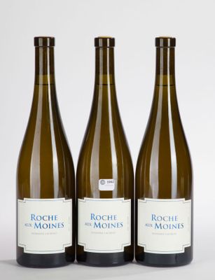 three bottles of wine are lined up on a white surface