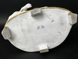 porcelain figurine of a cat laying on its back on a black surface
