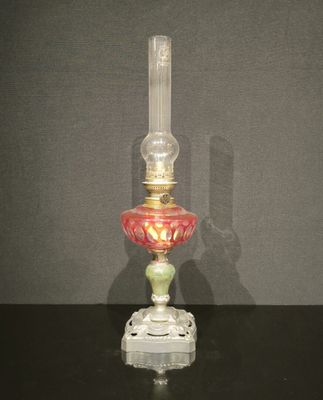 une lampe en verre ornée d'un motif rouge et vert