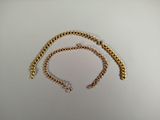 a close up of a gold chain on a white surface