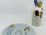 une assiette décorée d'un motif, à côté d'une bouteille de vin