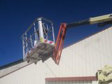 a man on a cherry picker working on the side of a building