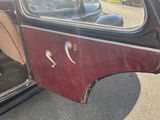 an old car with a door open on the side of the road