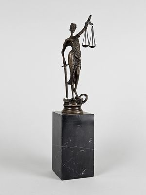 une statue en bronze représentant une femme tenant une balance, posée sur un socle en marbre