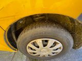 a yellow car that has a flat tire on the side of the road