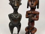 two wooden statues of a woman and a man on a white background