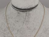 un collier en or orné d'un pendentif en forme de croissant autour du cou d'un mannequin