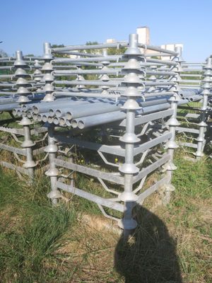 de nombreux tuyaux posés dans l'herbe près d'une clôture