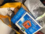 a bag of items sitting on the floor next to a laptop