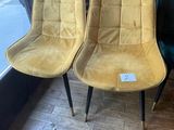 pair of yellow and green velvet chairs in front of a window