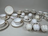 a lot of white and gold china on a table