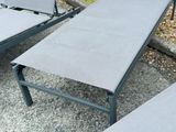 two lounge chairs and a table on the gravel
