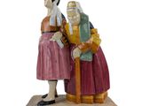 figurine of a man and a woman sitting on a bench
