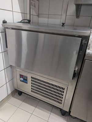 un réfrigérateur en acier inoxydable dans une cuisine carrelée