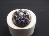 une bague dorée et bleue sur laquelle est représenté un visage