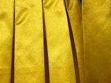 a close up of a yellow jacket with pleas on a mannequin mannequin mannequin mannequin mannequin mannequin manne