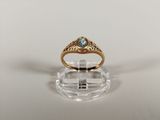 a close up of a gold ring with a blue topaz stone