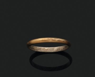 a close up of a gold ring on a black surface